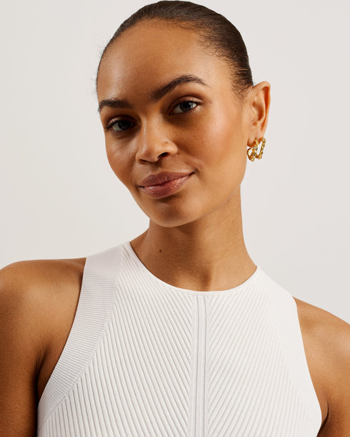 TIRSSO-Trousers-Switch up your special occasion fits with the TIRSSO jumpsuit. The top and trousers illusion brings effortless style, pairing a sleeveless bodice with wide leg bottoms for a flattering fit. The simple knitted top is elevated by a crossover neckline, and contrasts against the floral print of the trousers which adds a delicate pop of colour. Sleeveless jumpsuit Top and trousers illusion Pressed flower print Ribbed knit fitted bodice Crossover halter neck Wide leg trousers Exposed zip fastening